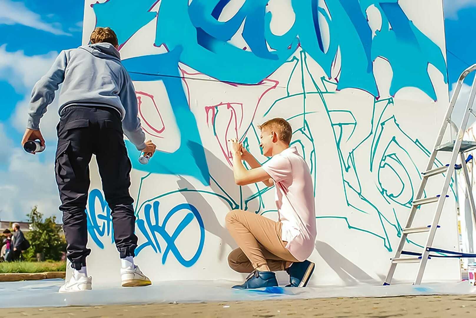 Подросток рисует на стене